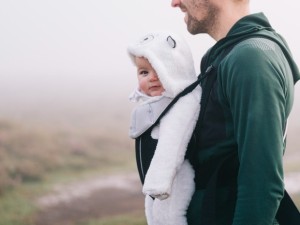 Pai caminha com seu filho preso ao peito